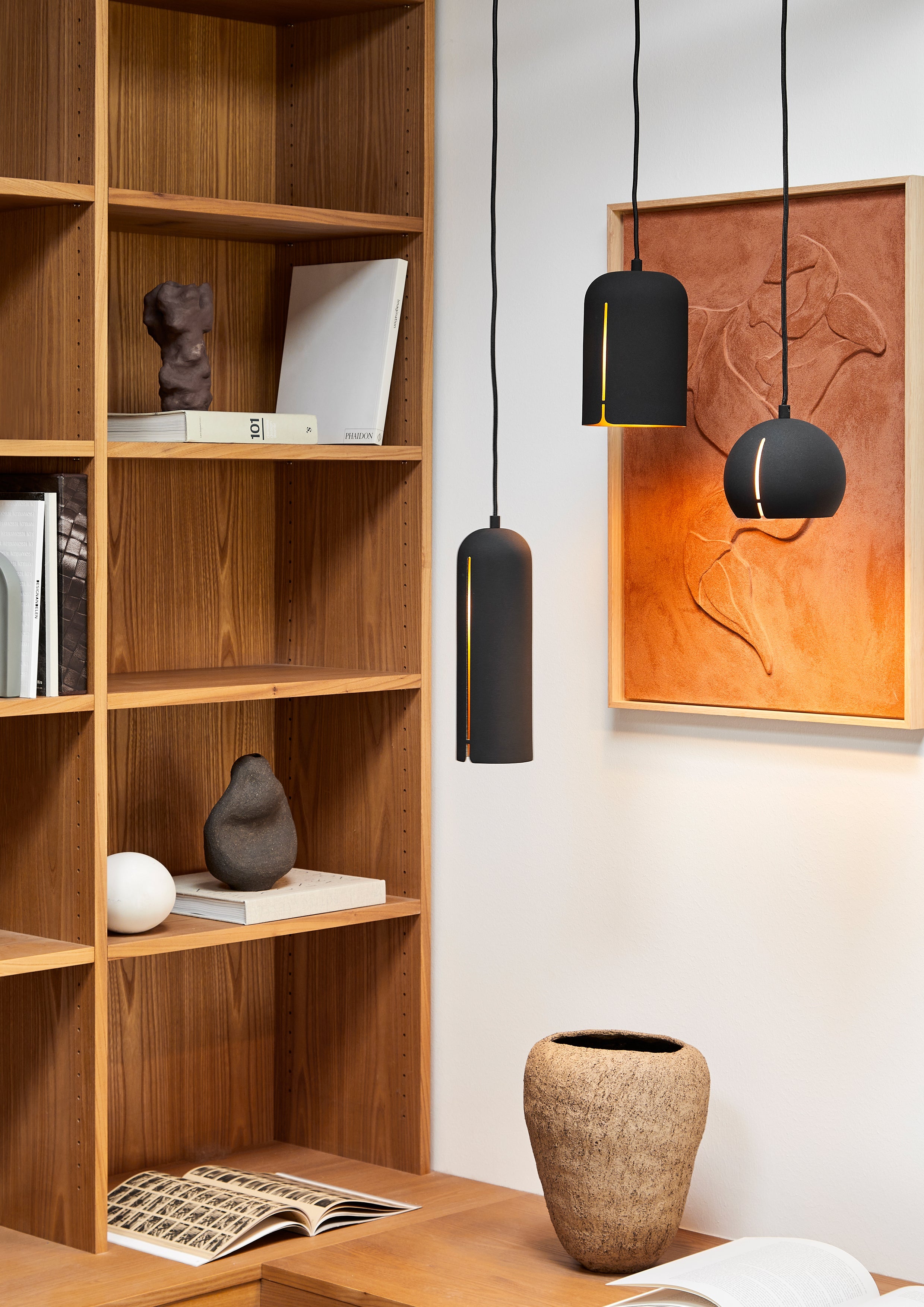 Klynge af minimalistiske sorte lamper med messingindvendig finish.