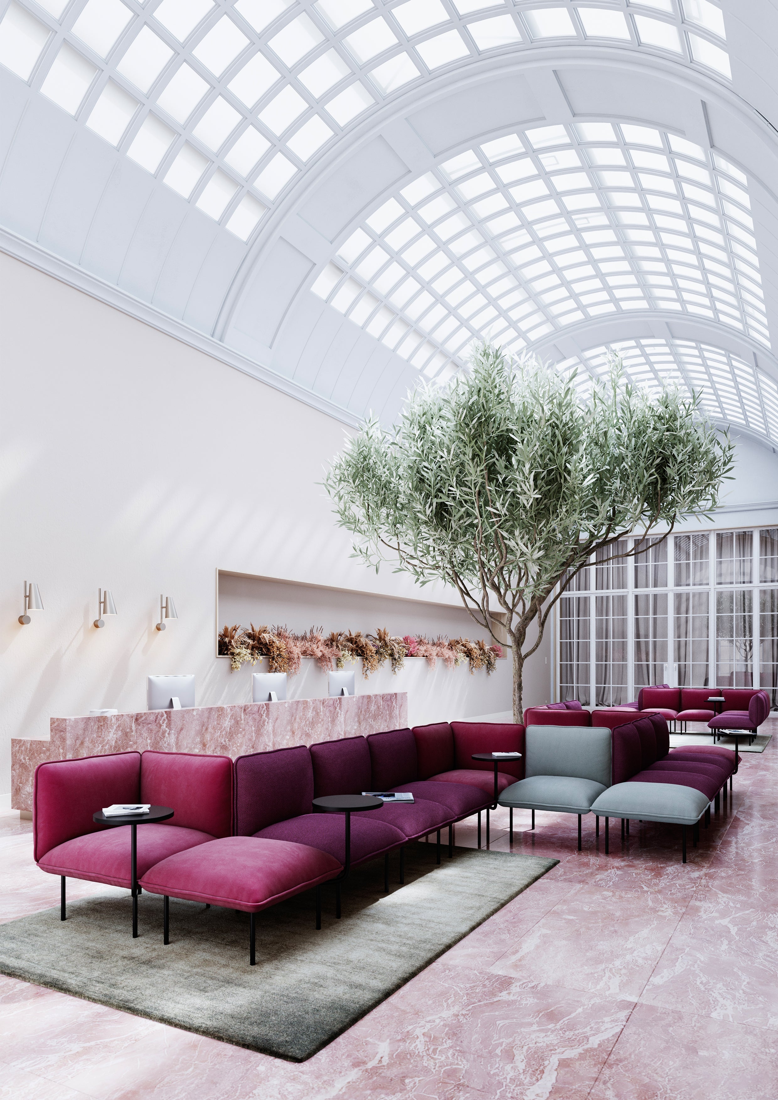 Stor modulsofa i flere farver placeret i lys hotel lobby.