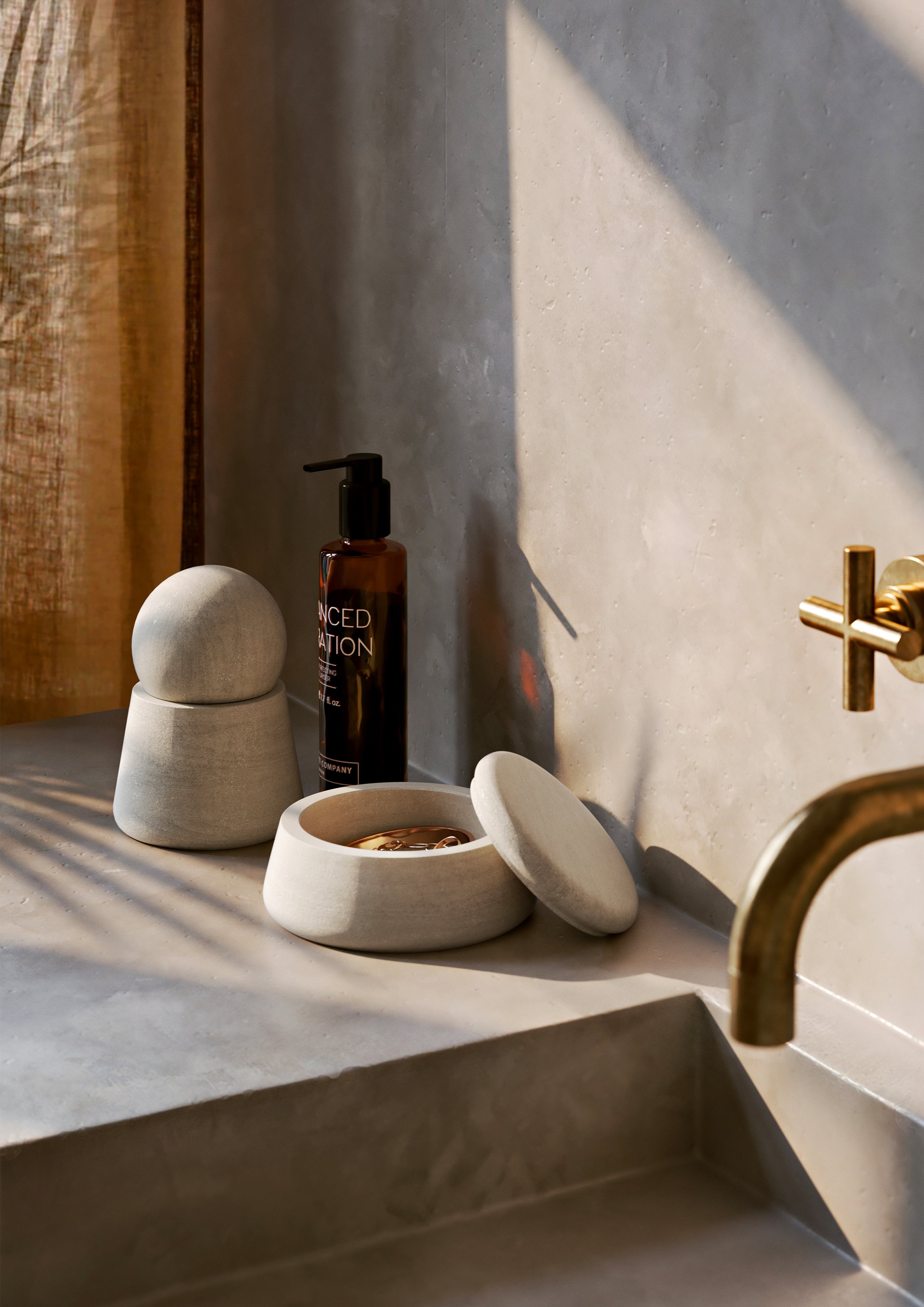 To runde krukker i naturlig sandsten på bordplade ved håndvask.