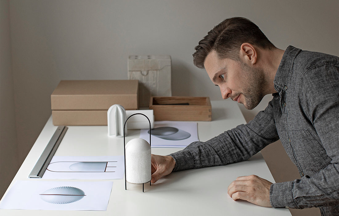 Designer Andreas Kowalewski ser på sin prototype af en lampe.
